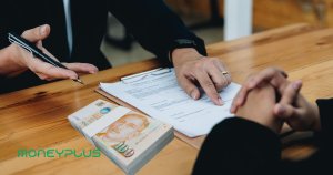 Borrower reviewing loan documents with a licensed money lender in Singapore, learning how to borrow money safely.